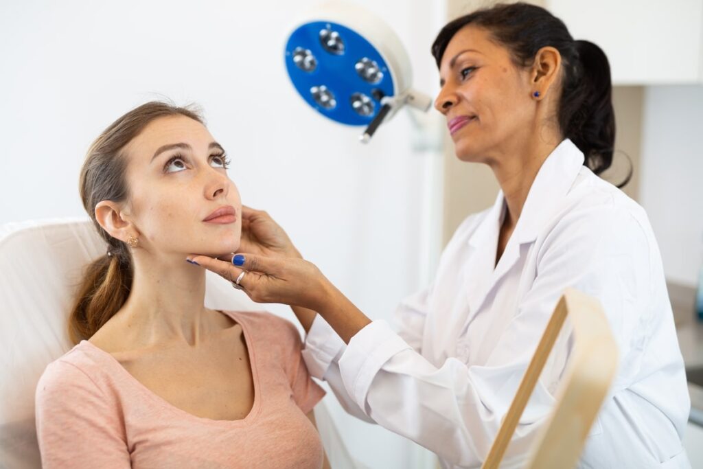 An experienced surgery dermatologist cheking the skin of a beautiful woman.