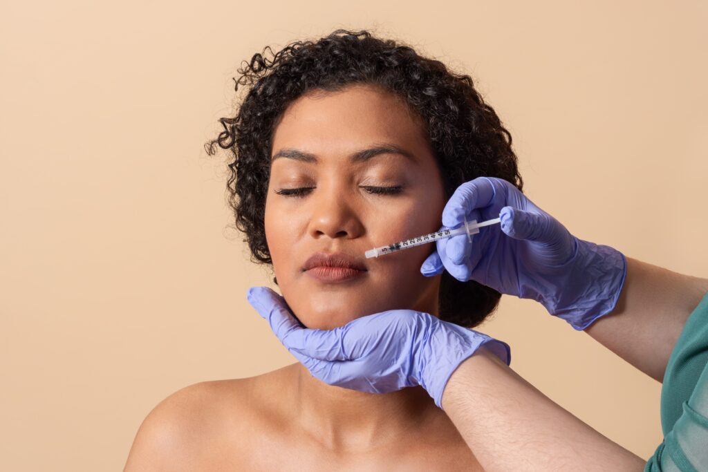 Woman receiving cosmetic lip injection treatment