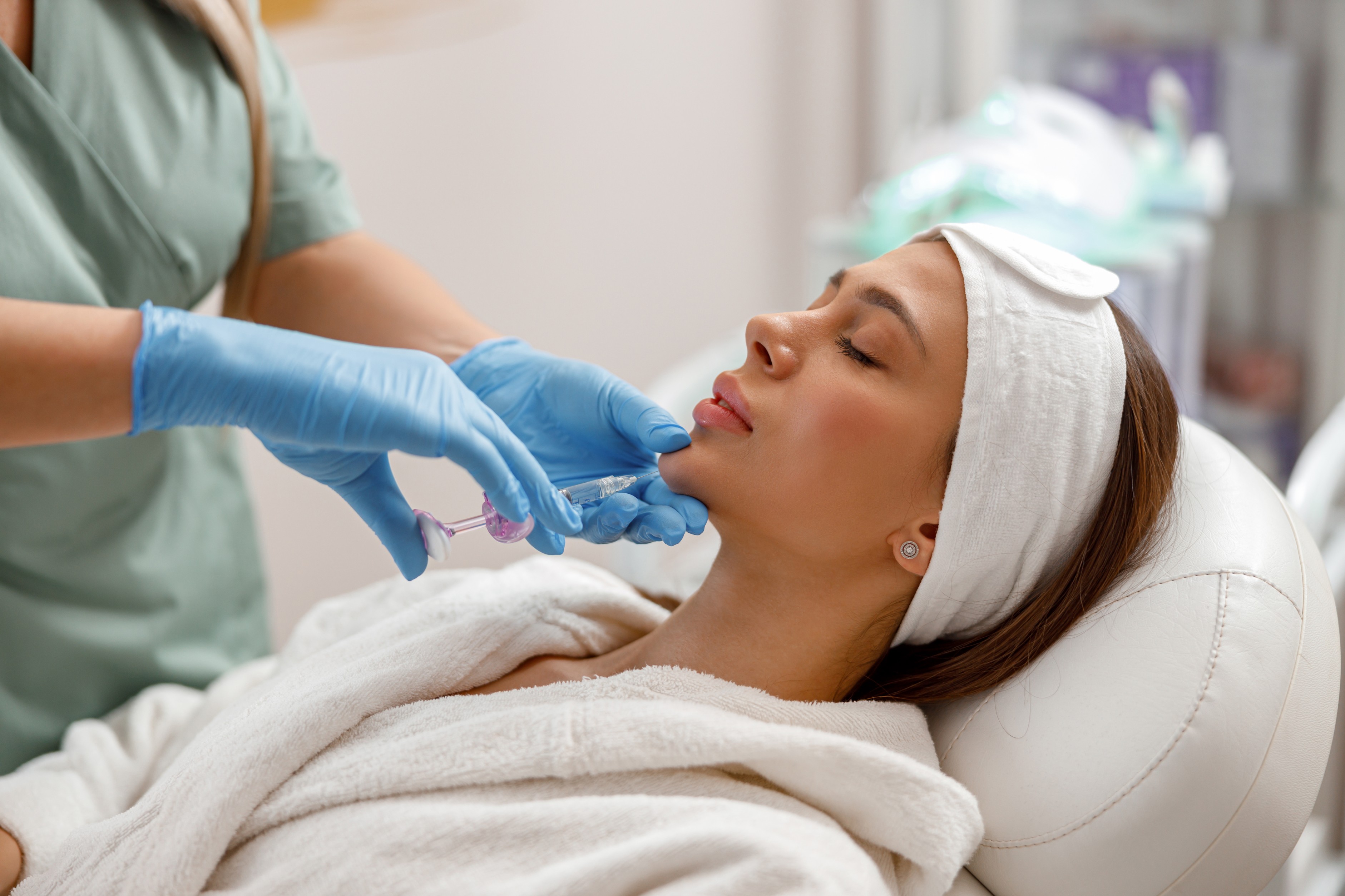 Woman receiving chin filler injection treatment