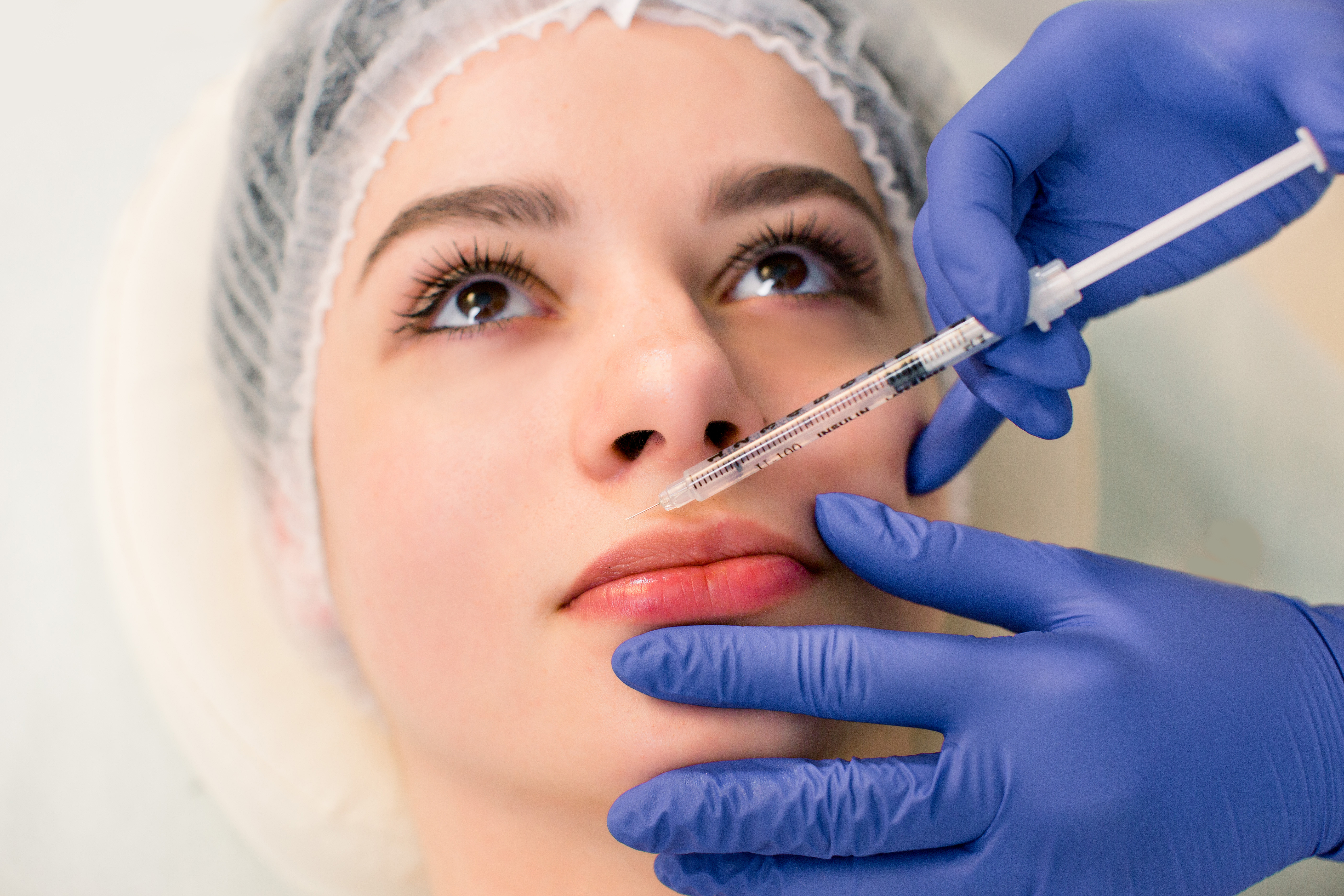 Woman getting lip filler injection treatment