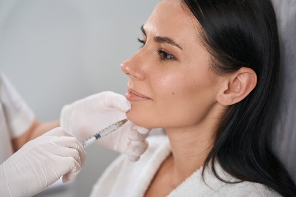 Woman receiving chin cosmetic injection treatment