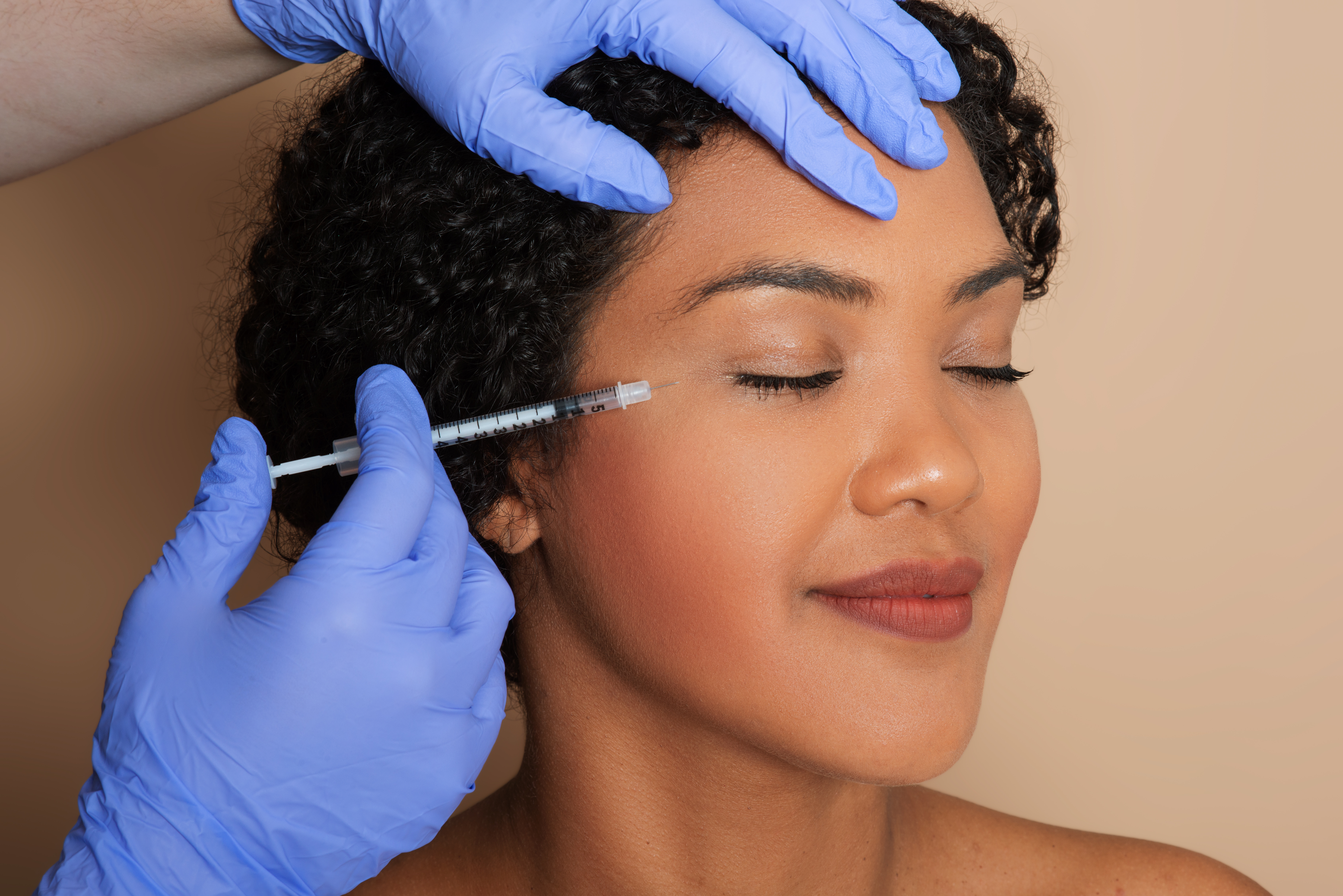 Cosmetic facial injection near woman's eye